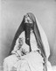 Click to see details of a veiled woman holding a jar.
